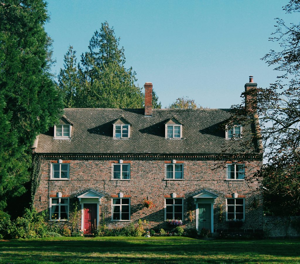 Traditional brick house set against a clear blue sky, reflecting stability in the UK property market
